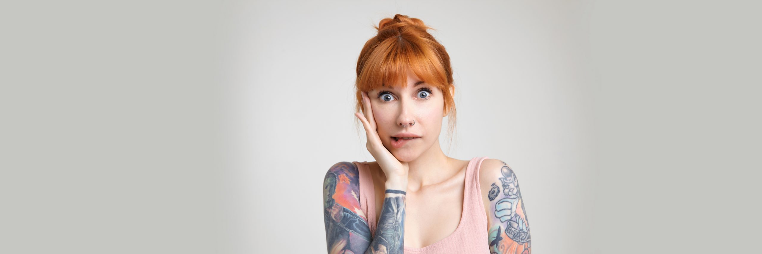 mulher ruiva tatuada com cara de preocupada